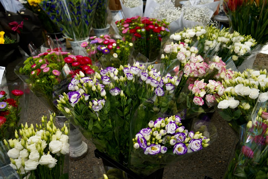 A vibrant display of fresh floral bouquets arranged with a variety of flowers including white lisianthus, purple and white eustoma, pink and white spray roses, miniature daisies in shades of pink and